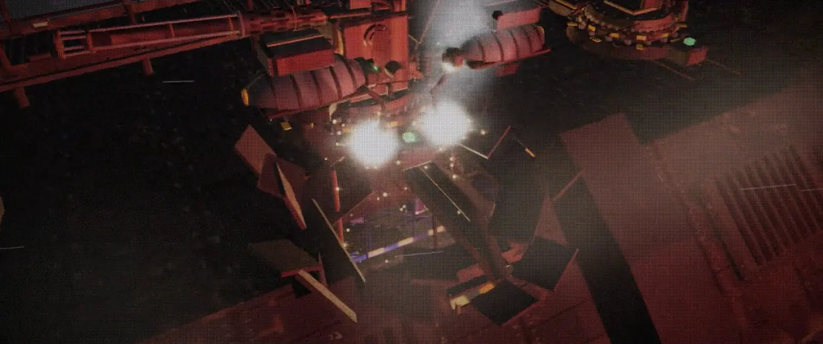 Repairer drones welding the cargo hall's roof in red light, sparks flying.